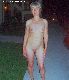 Skinny wife outdoors at night.